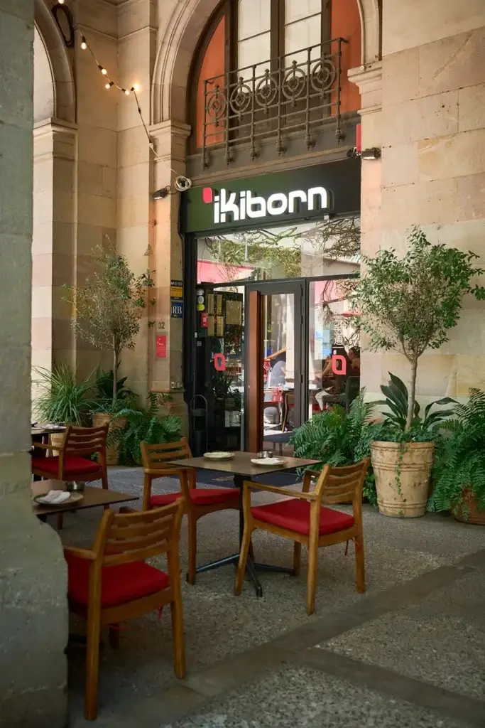 Terraza de IKIBORN de noche bajo los arcos del Born